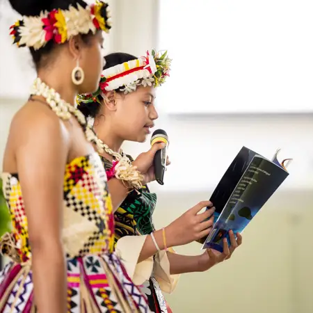 Image of a women holding a microphone for her friend speaking
