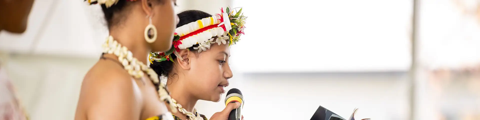 Image of a women holding a microphone for her friend speaking